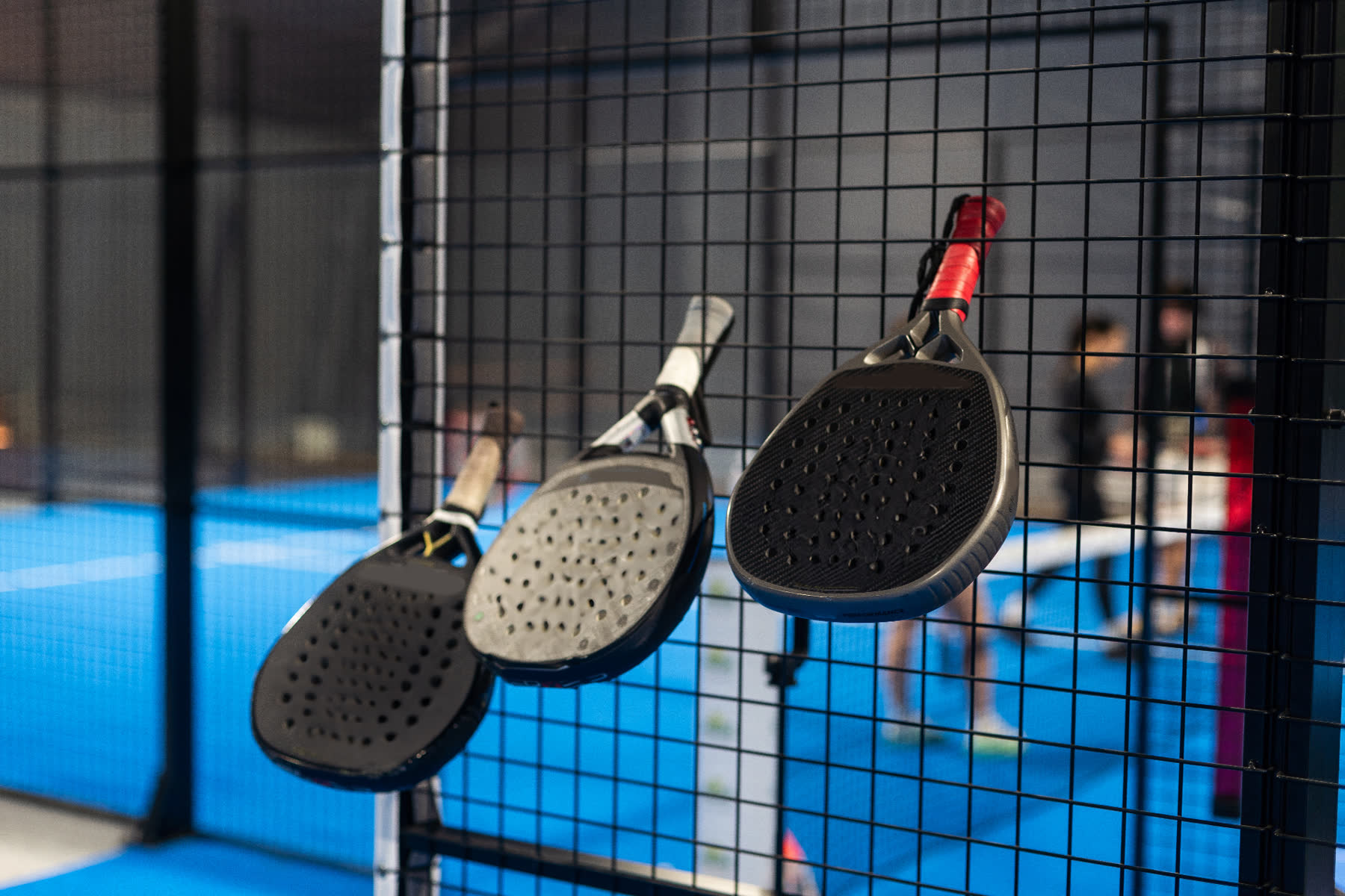 Paddles hanging on a court fence